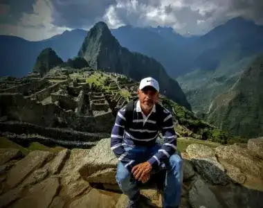 Señor con gorra blanca sentado en Machu Picchu